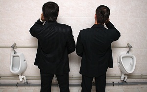 two-businessman-talking-on-phone-at-urinals